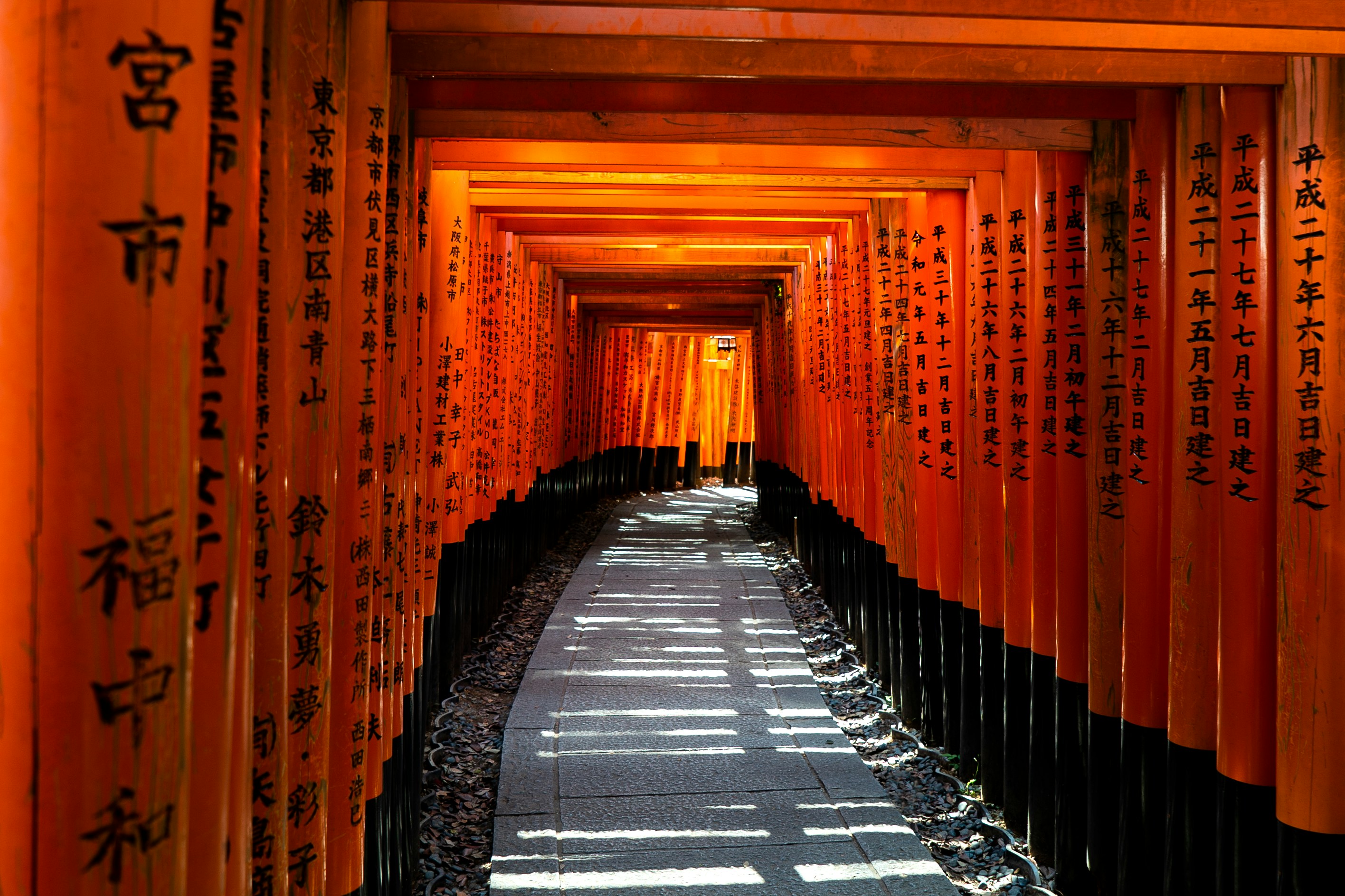 Narrow Edo-era street lined with dark wooden machiya and warm lanterns at dusk.