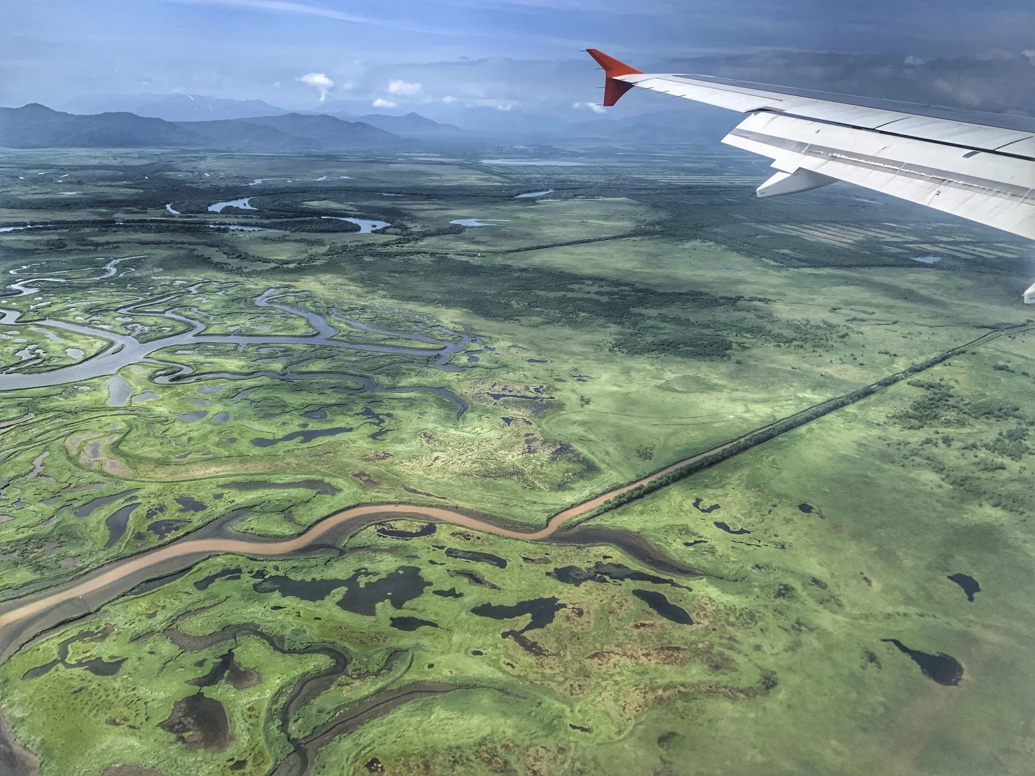 Wild green landscapes of Kamchatka with distant volcanoes