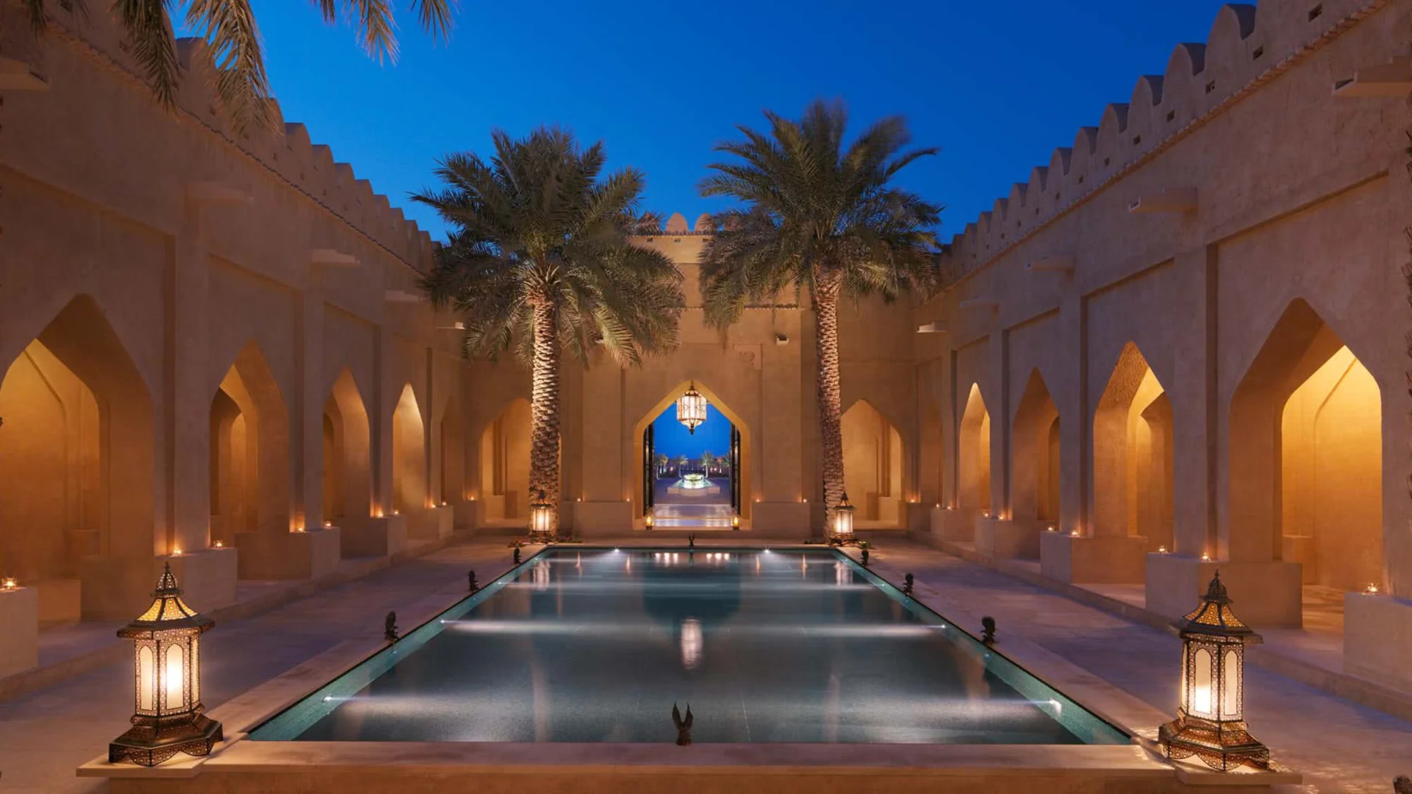 Desert resort courtyard illuminated at night.