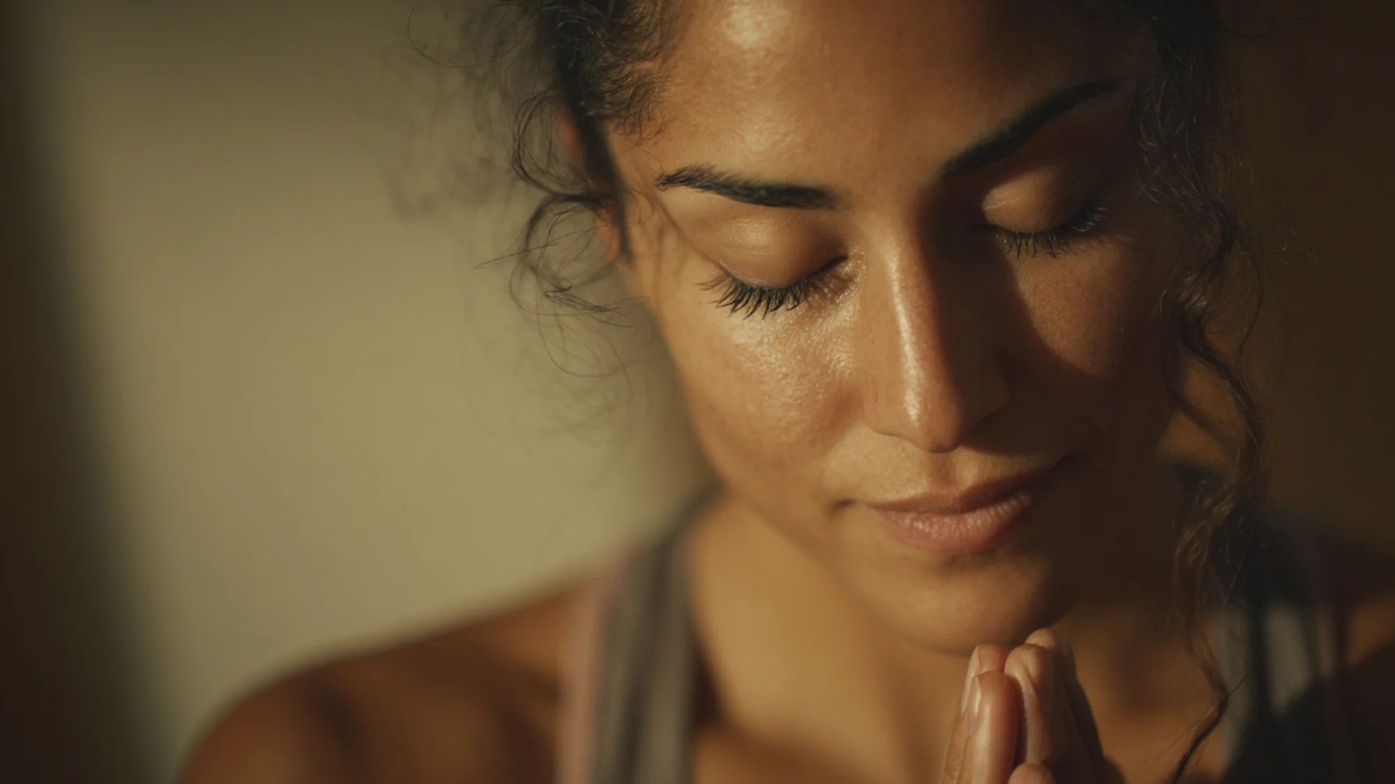 Person's torso showing ribs expanding during breath practice, warm candlelight, shallow depth of field.