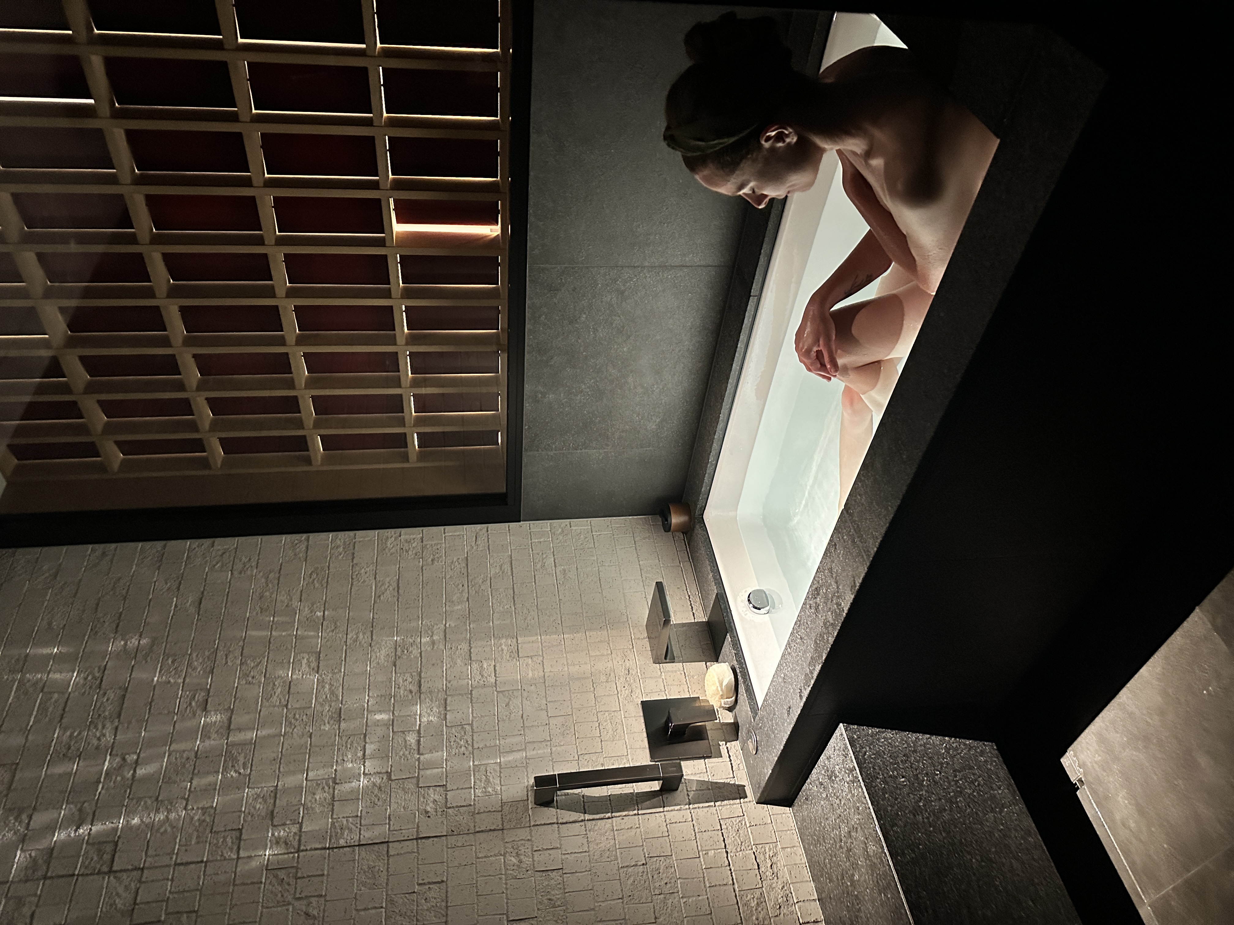 A woman in the bathtub of Six Senses Kyoto with mood lighting.