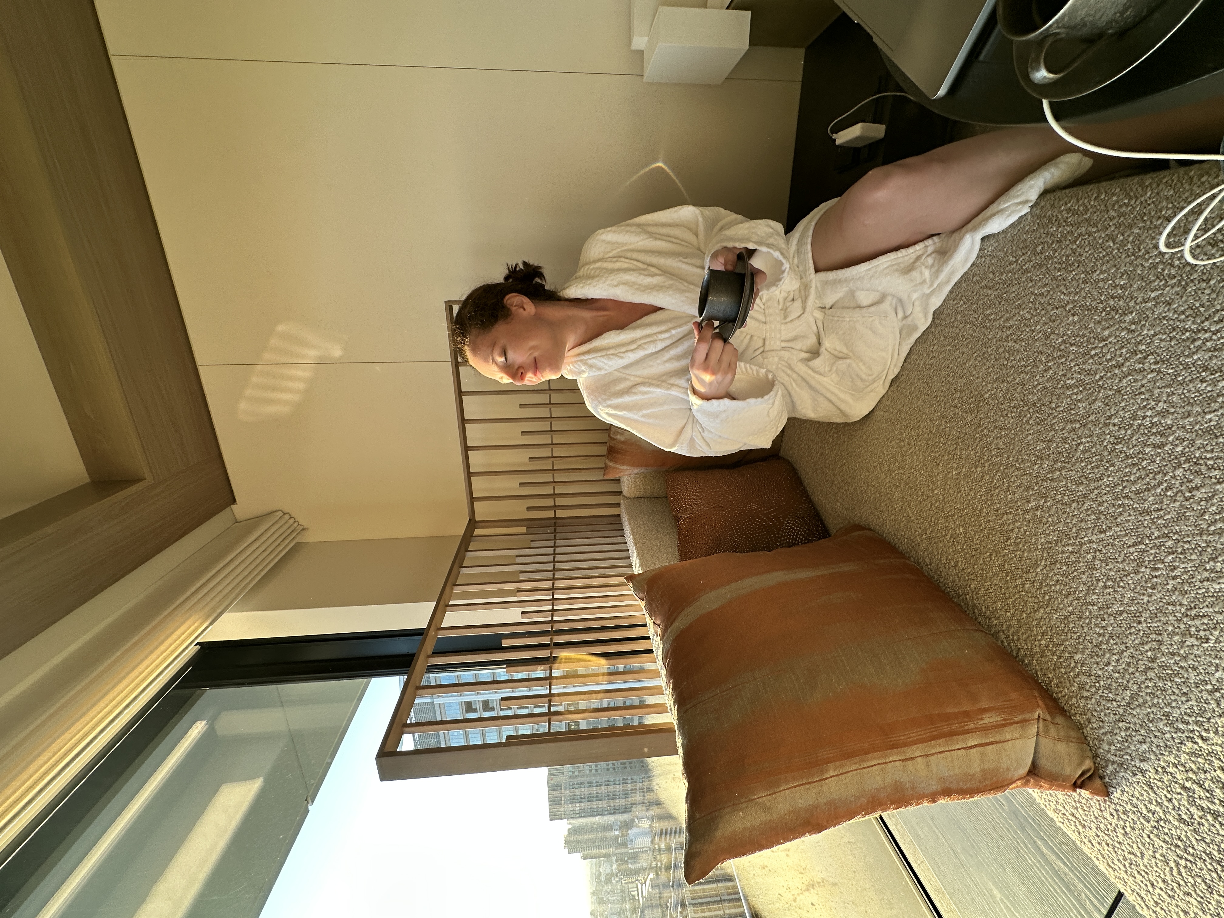 Krystal Ariel in a robe smiling with the sunrise shining on her face at Four Seasons Osaka