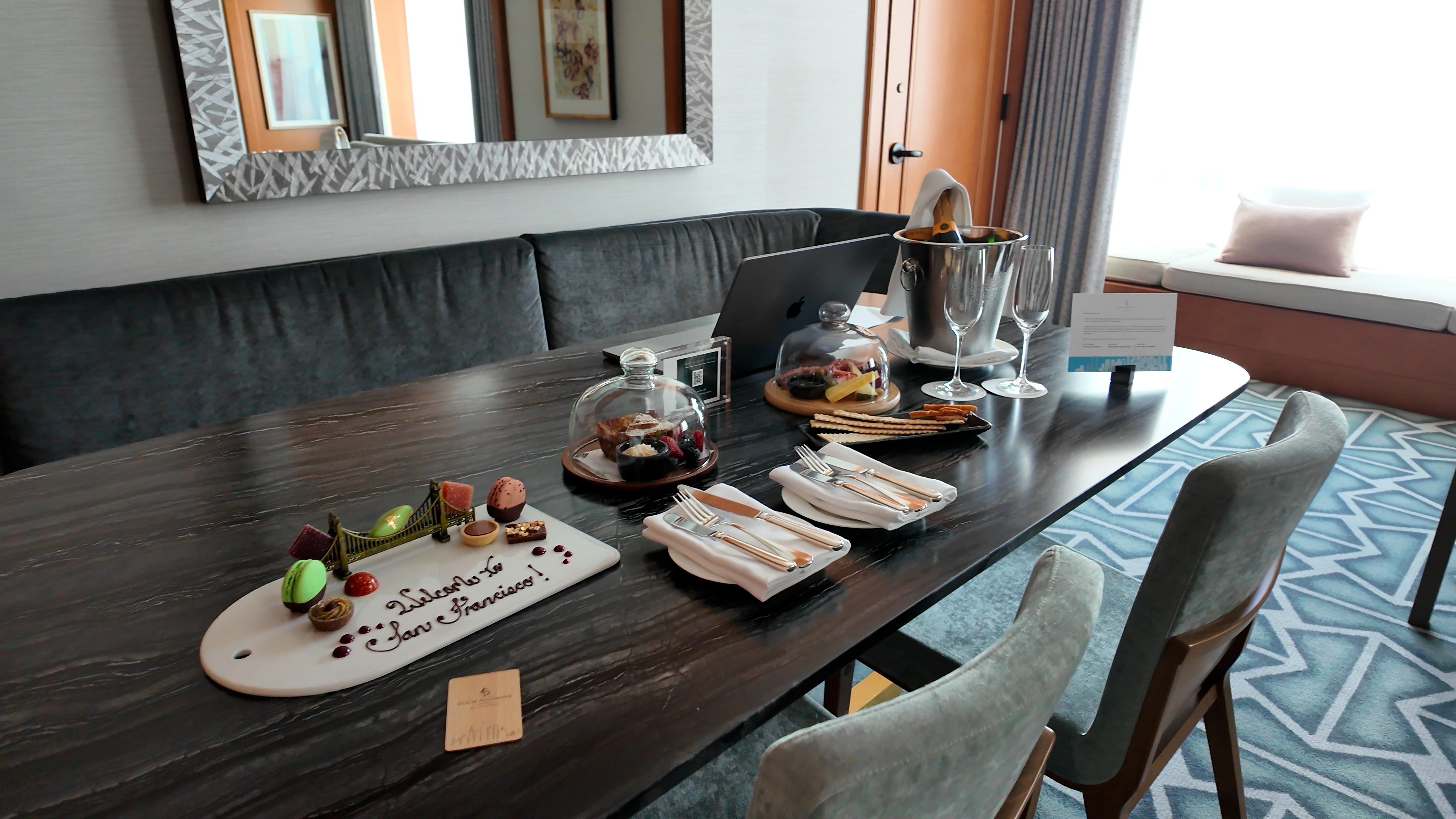 Welcome treats and champagne setup on the dining table in a Four Seasons San Francisco Premier Suite.