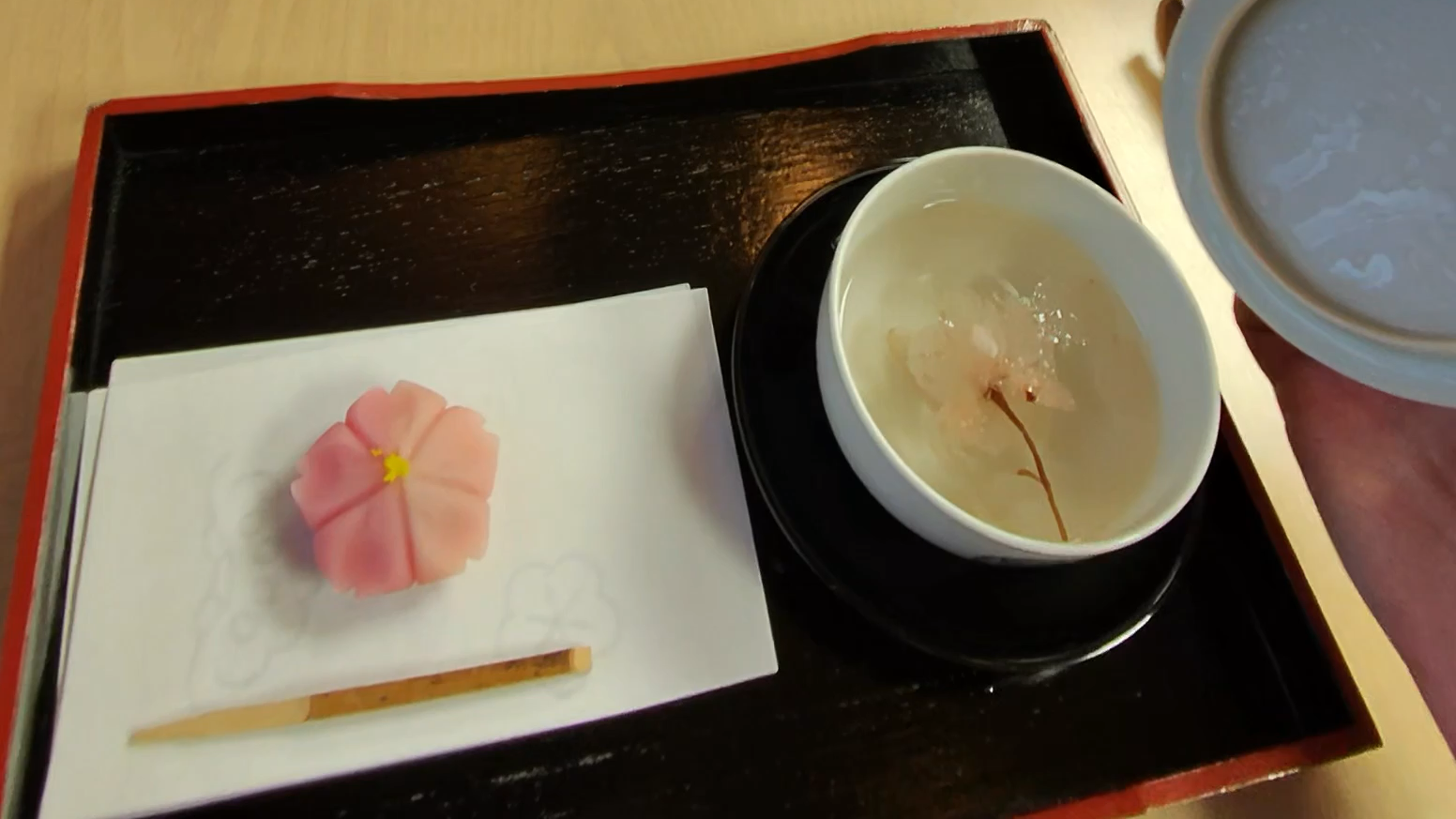 Sakura tea and pink sakura-shaped wagashi served during check-in at Takanawa Hanakohro.