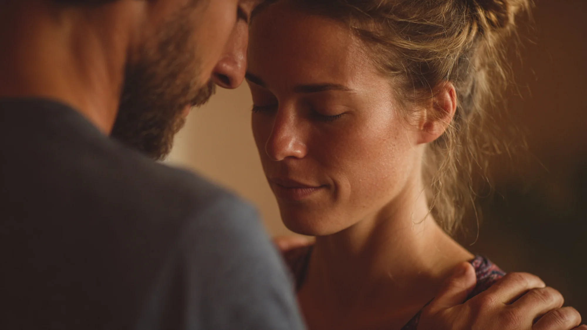 Woman during breath practice with calm focused expression, warm indoor lighting.